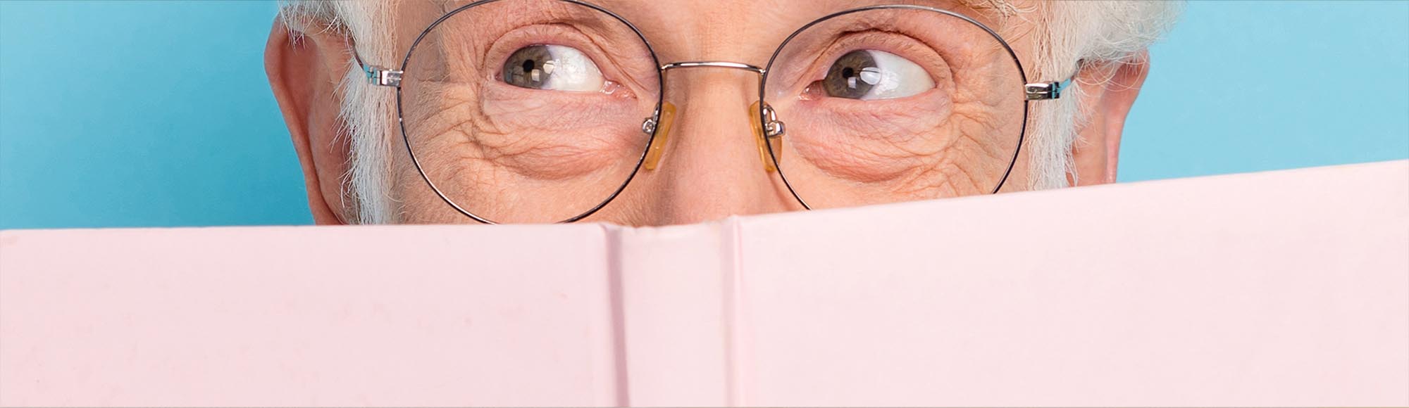 a person reading a book with an excited, wide-eyed look
