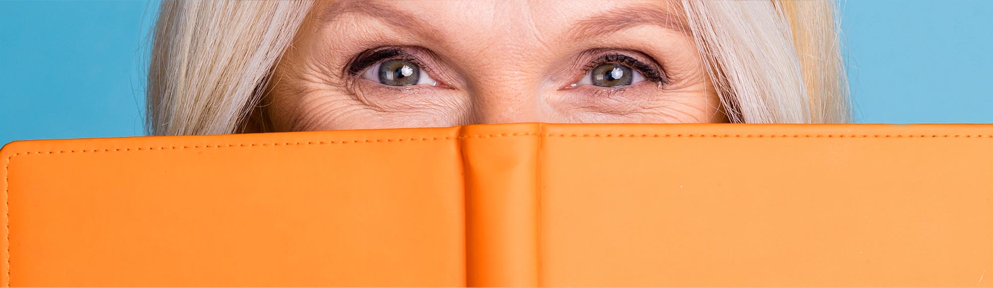 a person reading a book with an excited, wide-eyed look