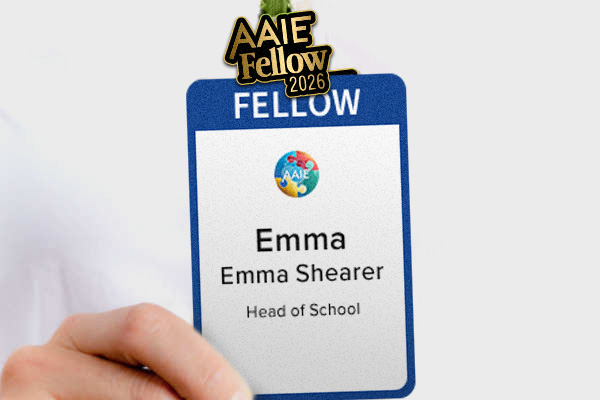 a woman's hand holding an AAIE Conference Fellow badge with an attached