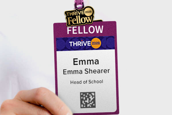 a woman's hand holding an NAIS Thrive 2026 Conference Fellow badge with an attached pin.